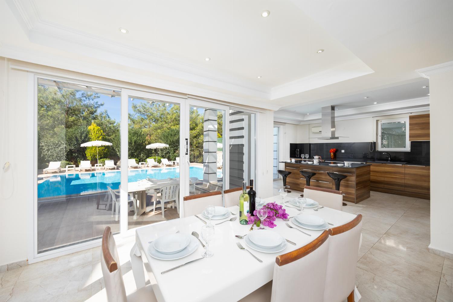 Open-plan living room with sofas, dining area, kitchen, A/C, WiFi internet, and satellite TV