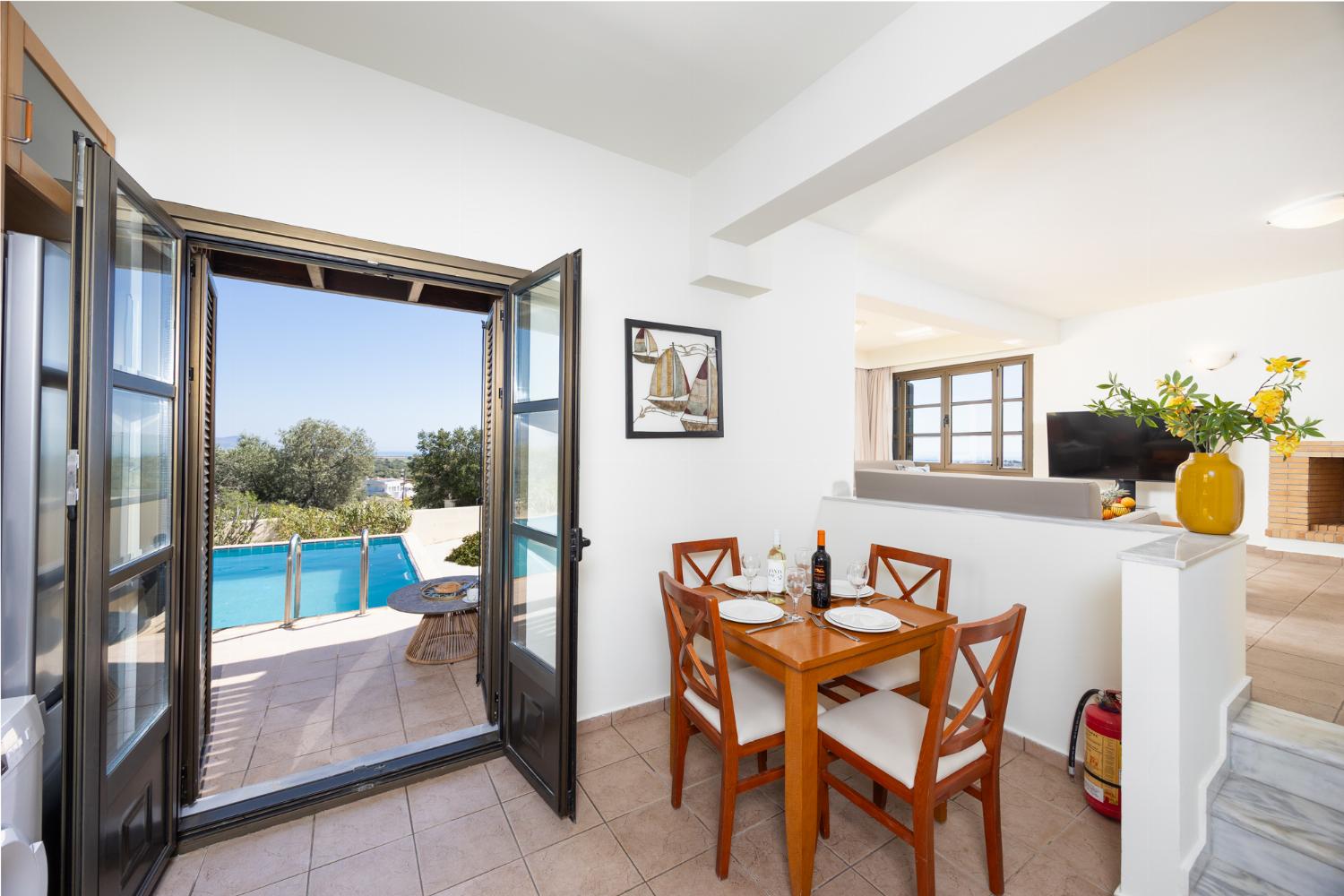 Open-plan living room with sofa, dining area, kitchen, ornamental fireplace, A/C, WiFi internet, and satellite TV