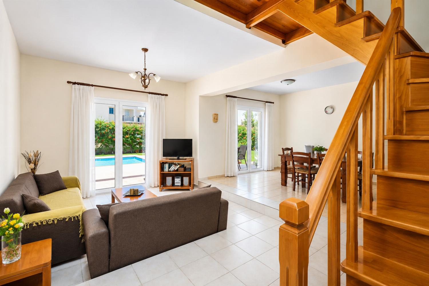 Open-plan living room with sofa, dining area, kitchen, A/C, WiFi internet, and satellite TV