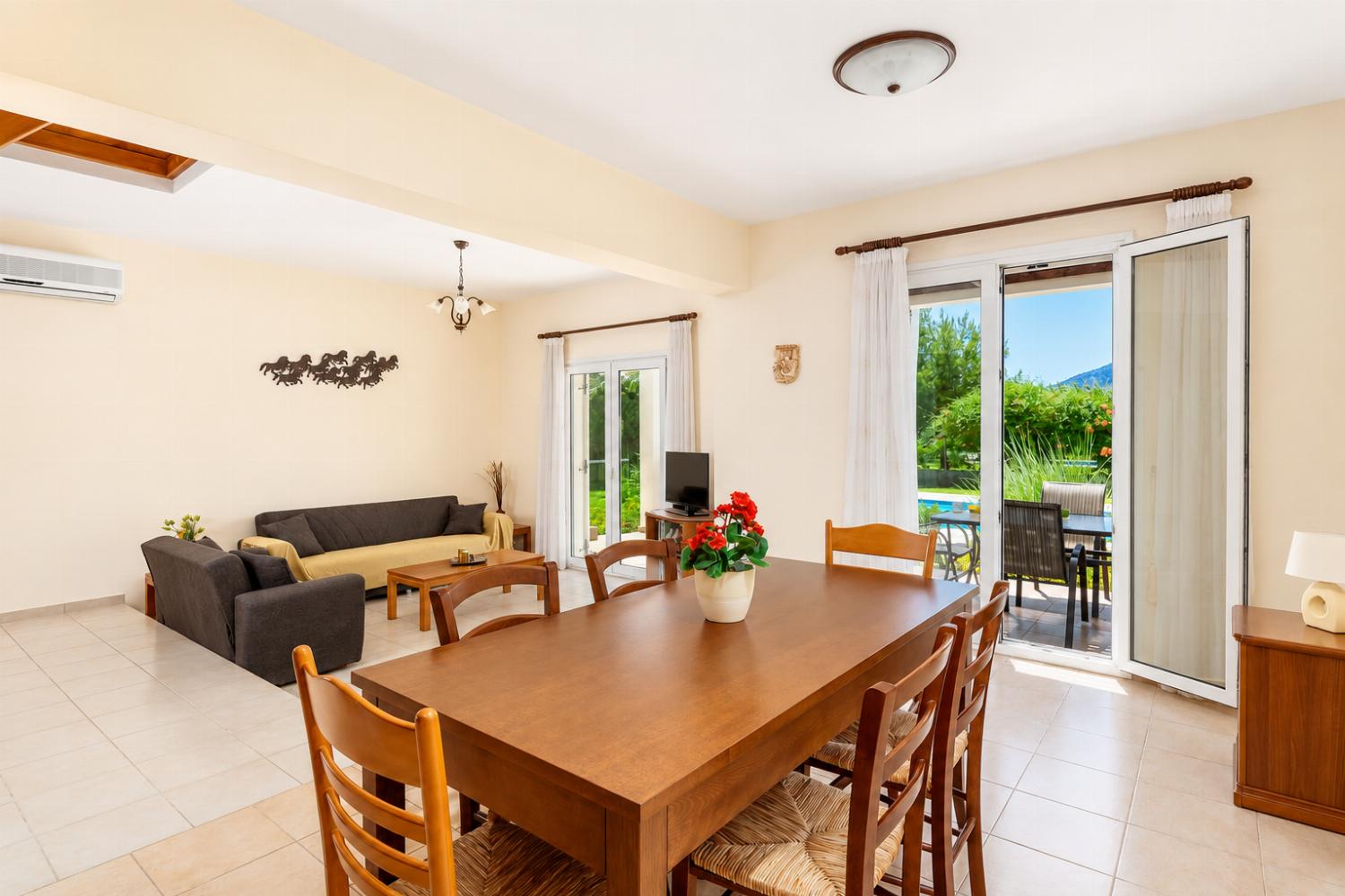 Open-plan living room with sofa, dining area, kitchen, A/C, WiFi internet, and satellite TV