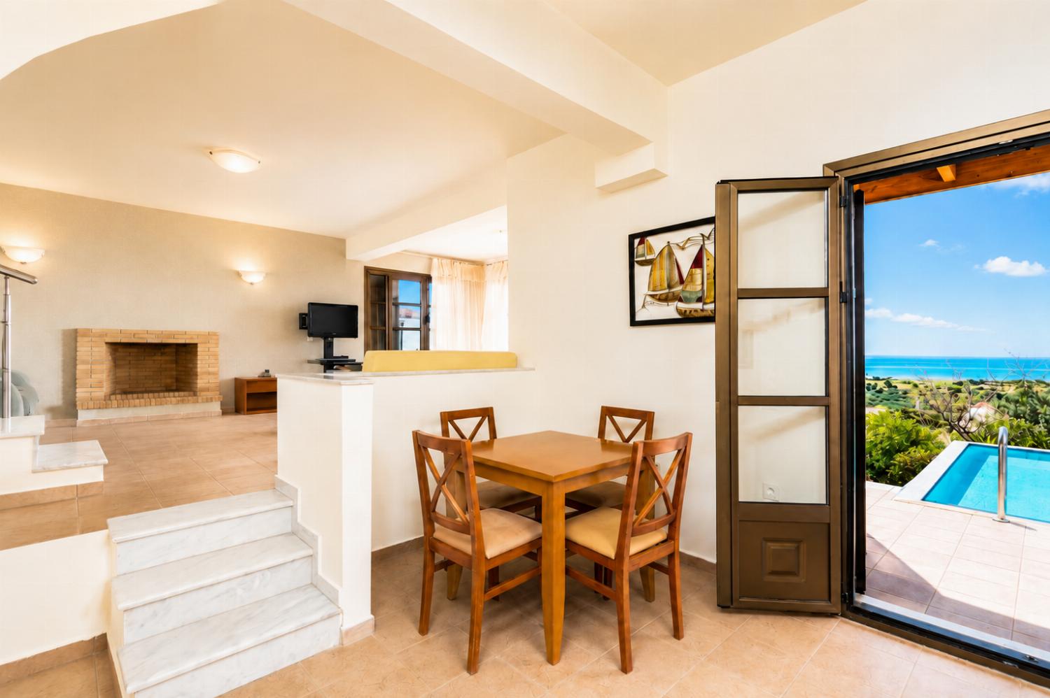 Open-plan living room with sofa, dining area, kitchen, A/C, WiFi internet, and satellite TV