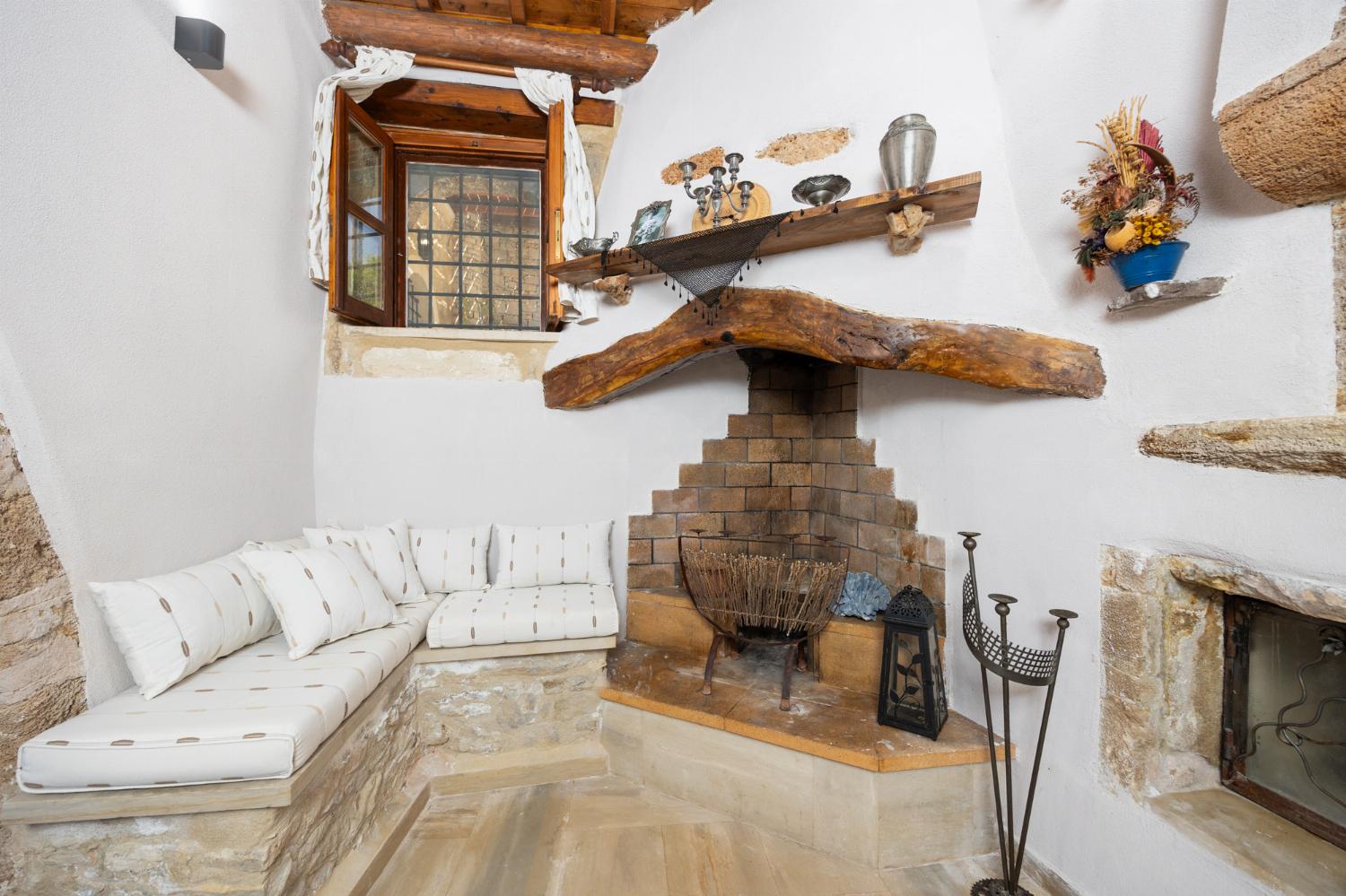 Living room with sofa, ornamental fireplace, A/C, WiFi internet, and satellite TV