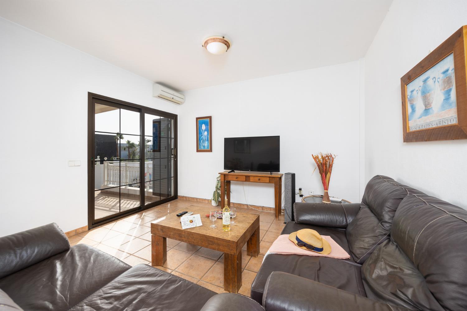 Living room with sofas, dining area, A/C, WiFi internet, and satellite TV