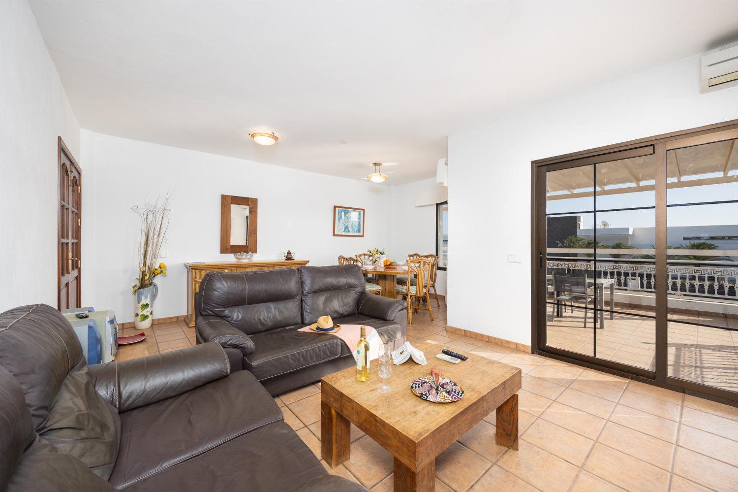 Living room with sofas, dining area, A/C, WiFi internet, and satellite TV