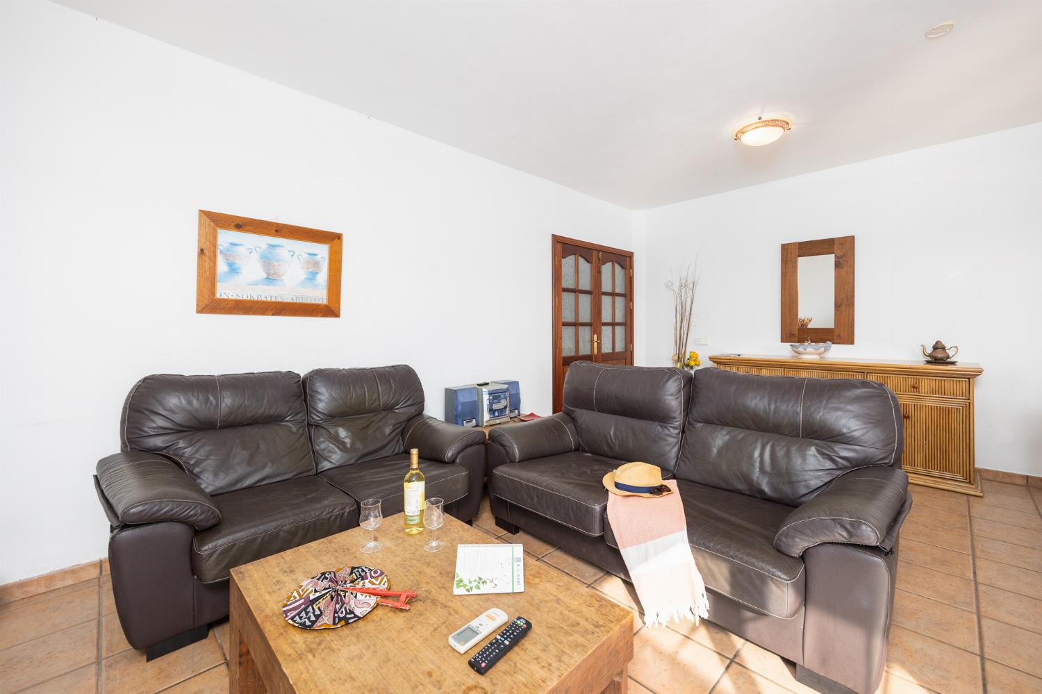 Living room with sofas, dining area, A/C, WiFi internet, and satellite TV