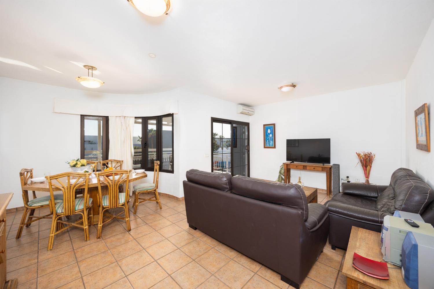 Living room with sofas, dining area, A/C, WiFi internet, and satellite TV