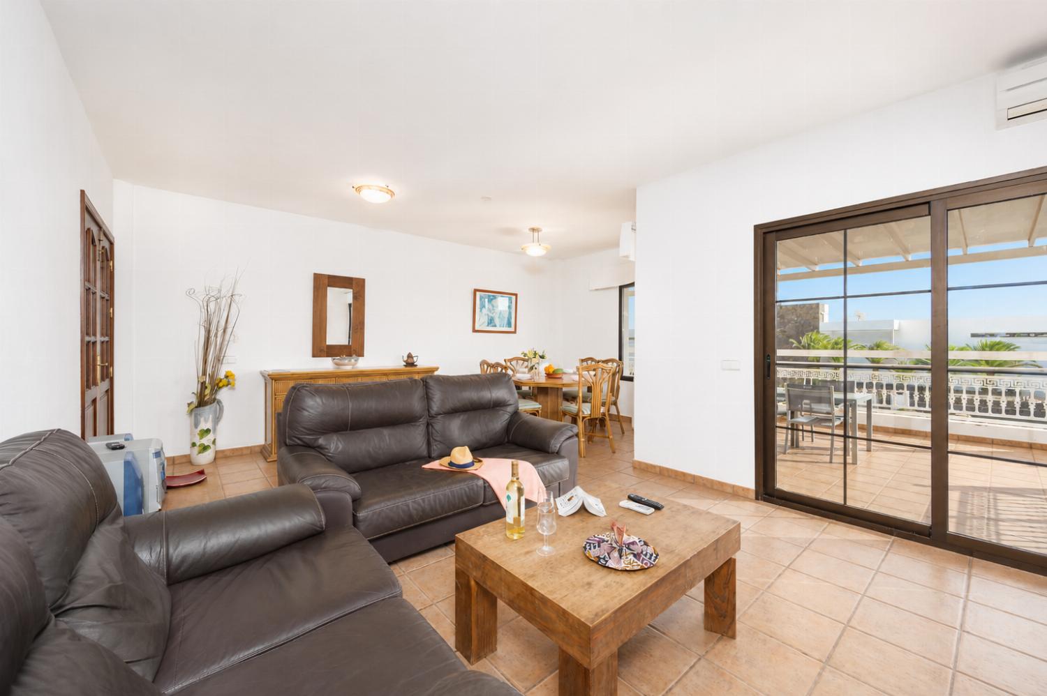 Living room with sofas, dining area, A/C, WiFi internet, and satellite TV