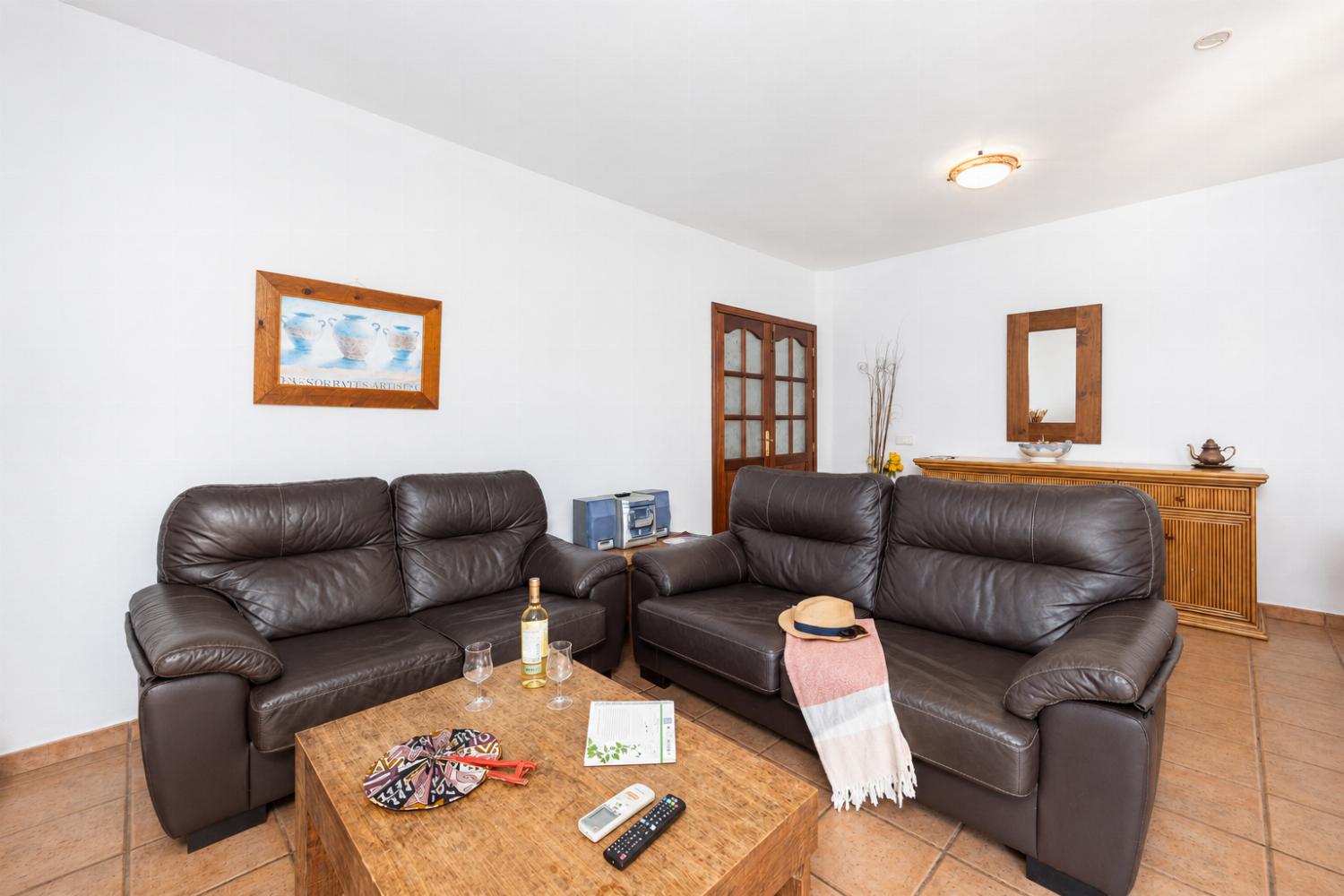 Living room with sofas, dining area, A/C, WiFi internet, and satellite TV