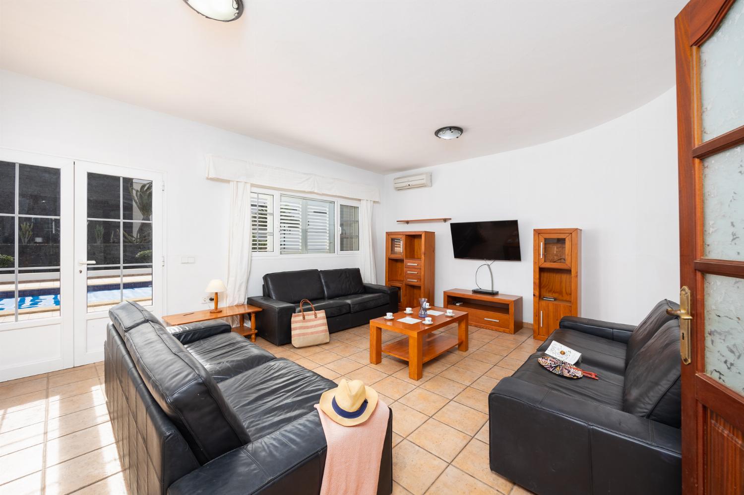 Living room with sofas, dining area, A/C, WiFi internet, and satellite TV