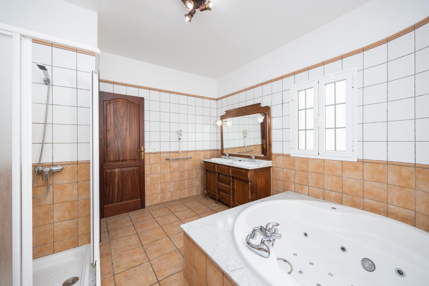 En suite bathroom with jacuzzi and shower
