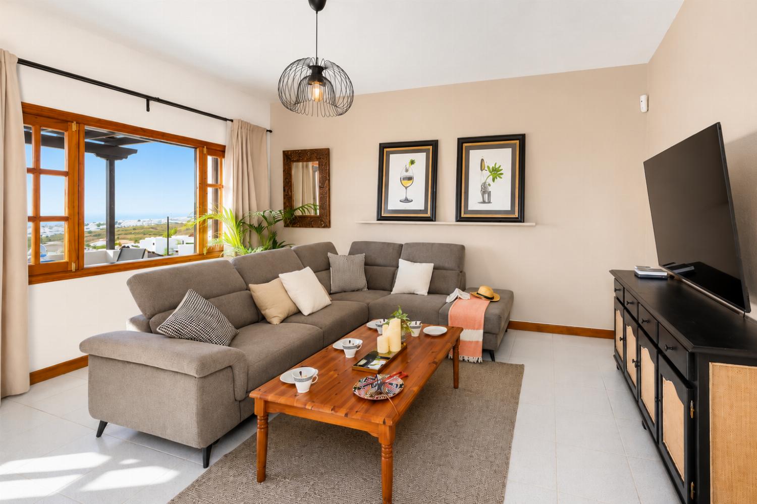 Living room with sofa, ornamental fireplace, A/C, WiFi internet, and satellite TV