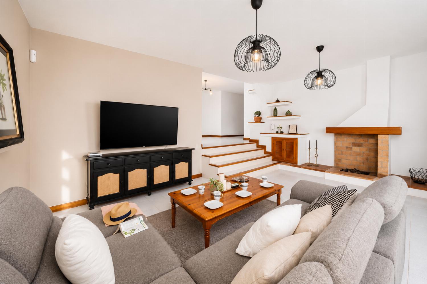 Living room with sofa, ornamental fireplace, A/C, WiFi internet, and satellite TV