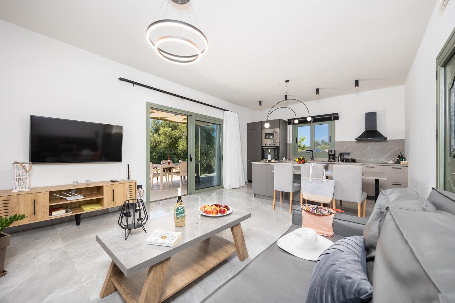 Open-plan living room with sofa, kitchen, A/C, WiFi internet, and satellite TV