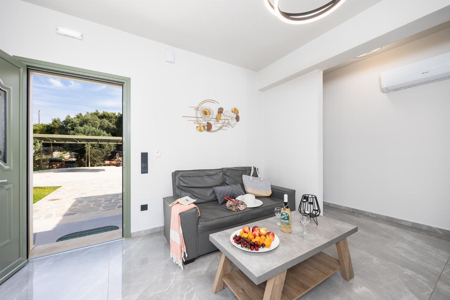 Open-plan living room with sofa, kitchen, A/C, WiFi internet, and satellite TV