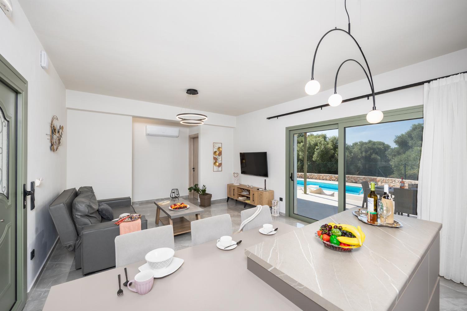 Open-plan living room with sofa, kitchen, A/C, WiFi internet, and satellite TV
