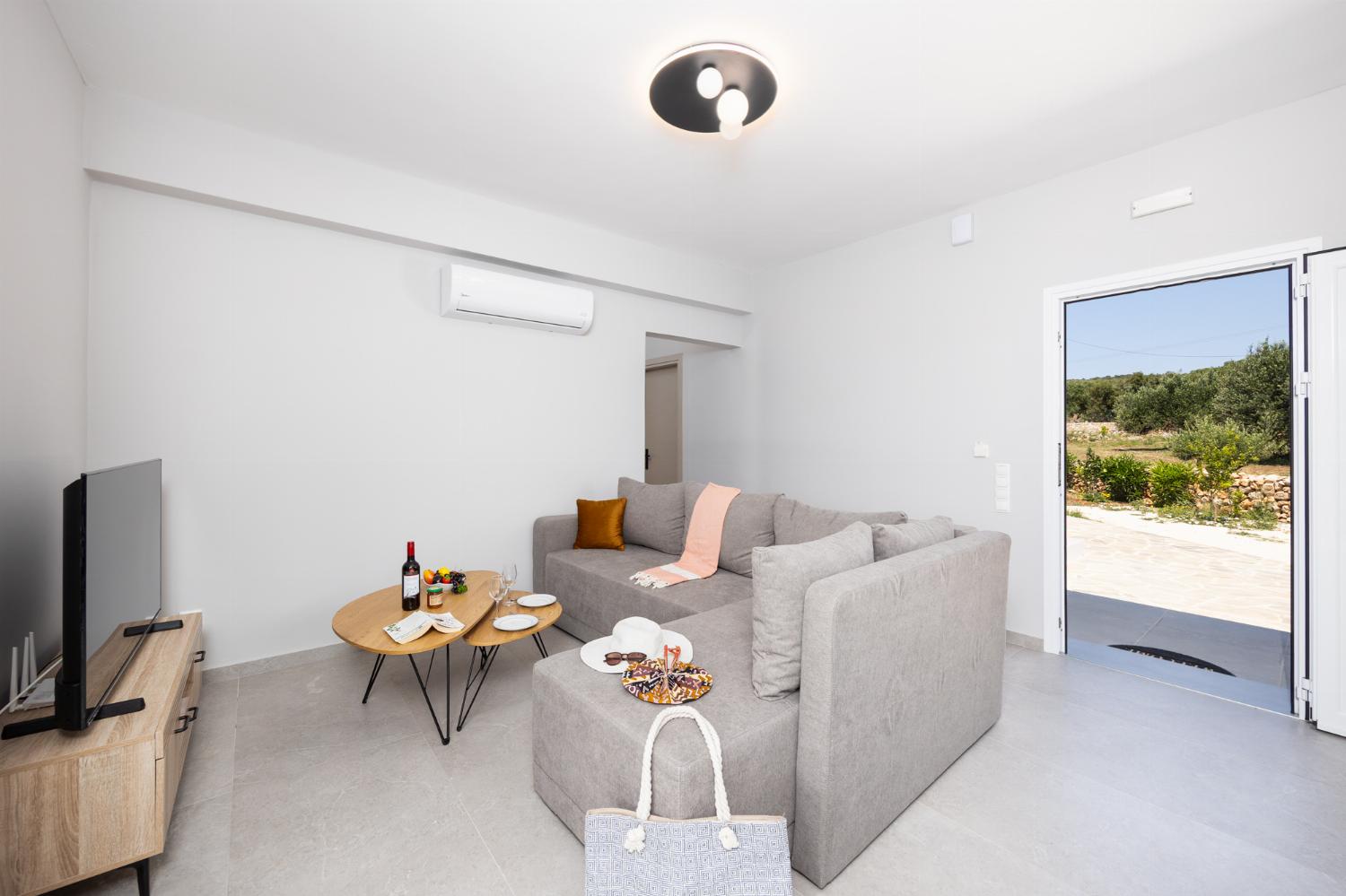 Open-plan living room with sofa, kitchen, A/C, WiFi internet, and satellite TV
