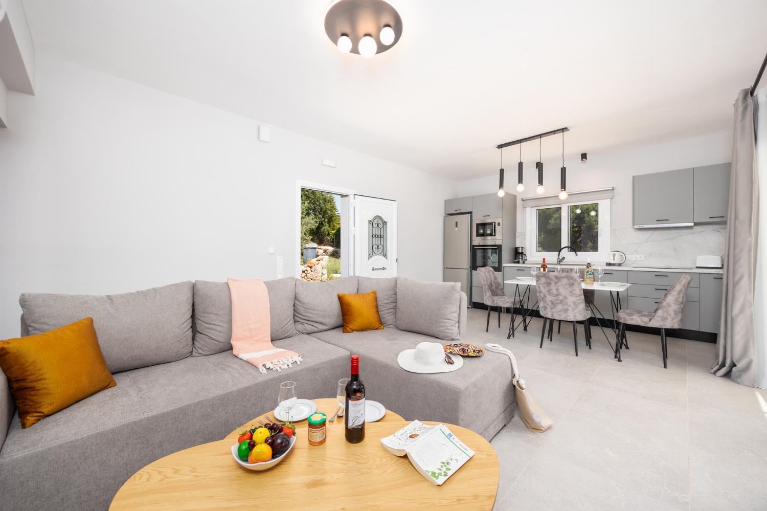 Open-plan living room with sofa, kitchen, A/C, WiFi internet, and satellite TV