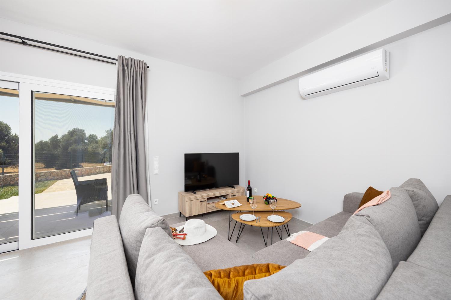 Open-plan living room with sofa, kitchen, A/C, WiFi internet, and satellite TV