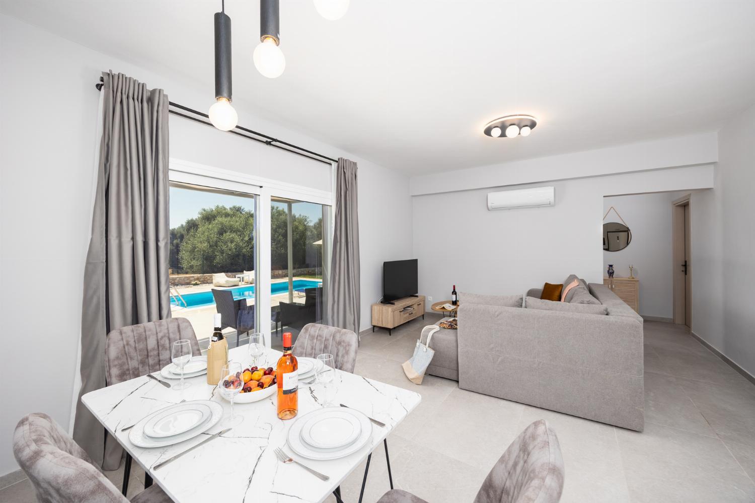 Open-plan living room with sofa, kitchen, A/C, WiFi internet, and satellite TV