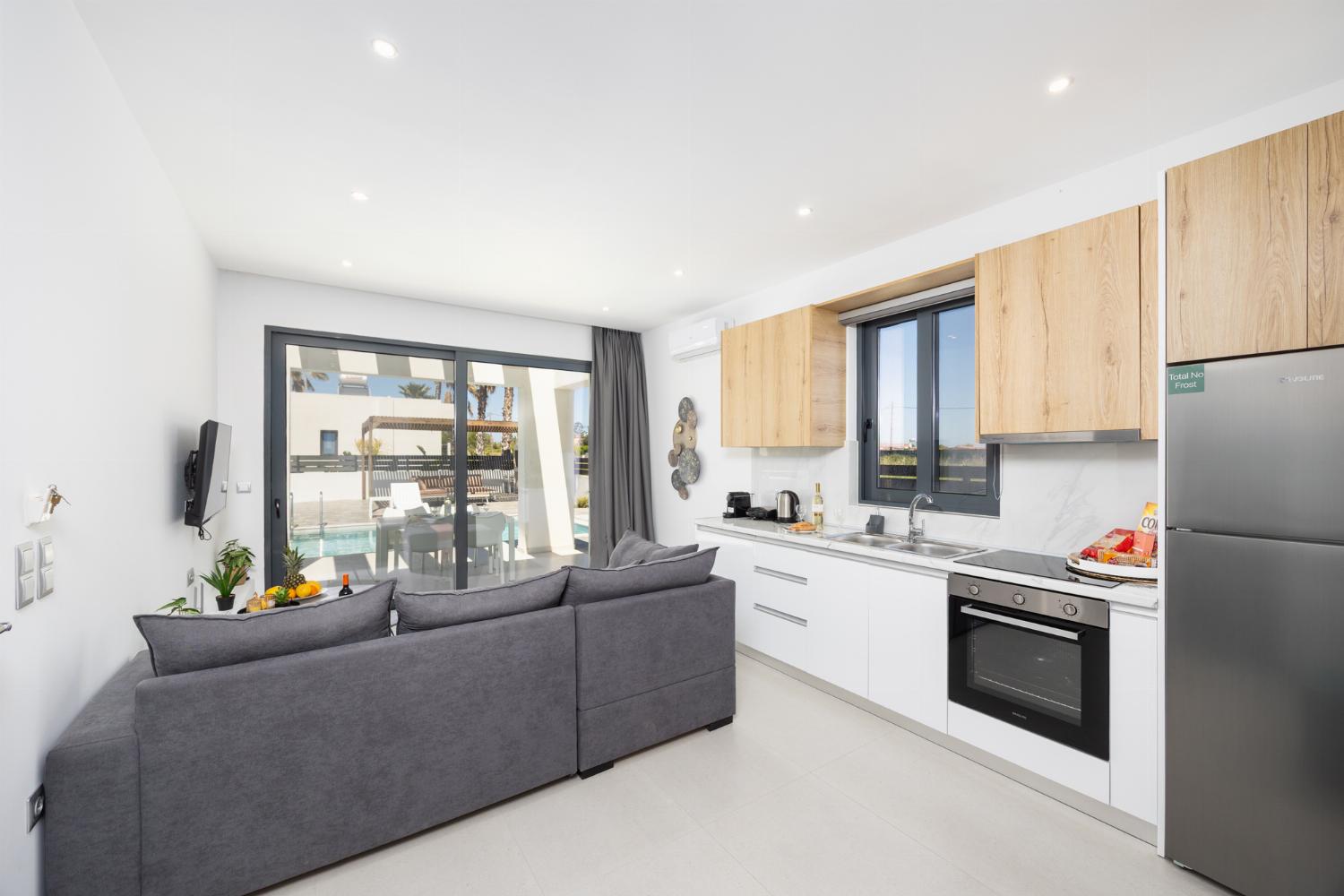 Open-plan living room with sofa, kitchen, A/C, WiFi internet, and satellite TV