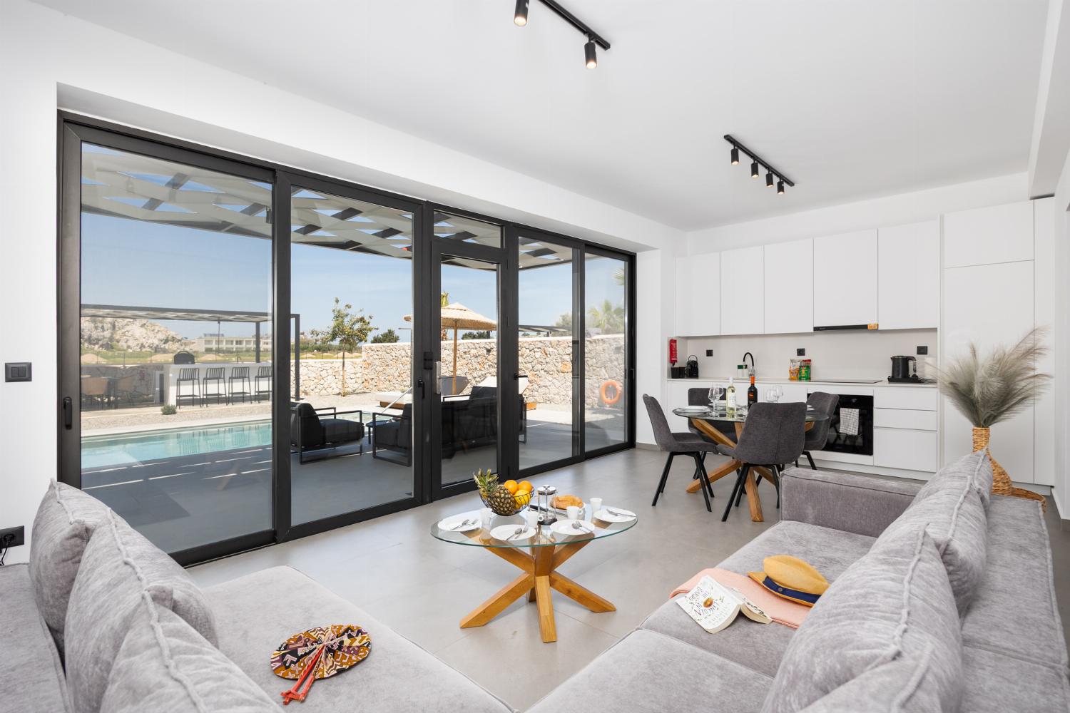 Open-plan living room with sofa, dining area, kitchen, A/C, WiFi internet, and satellite TV