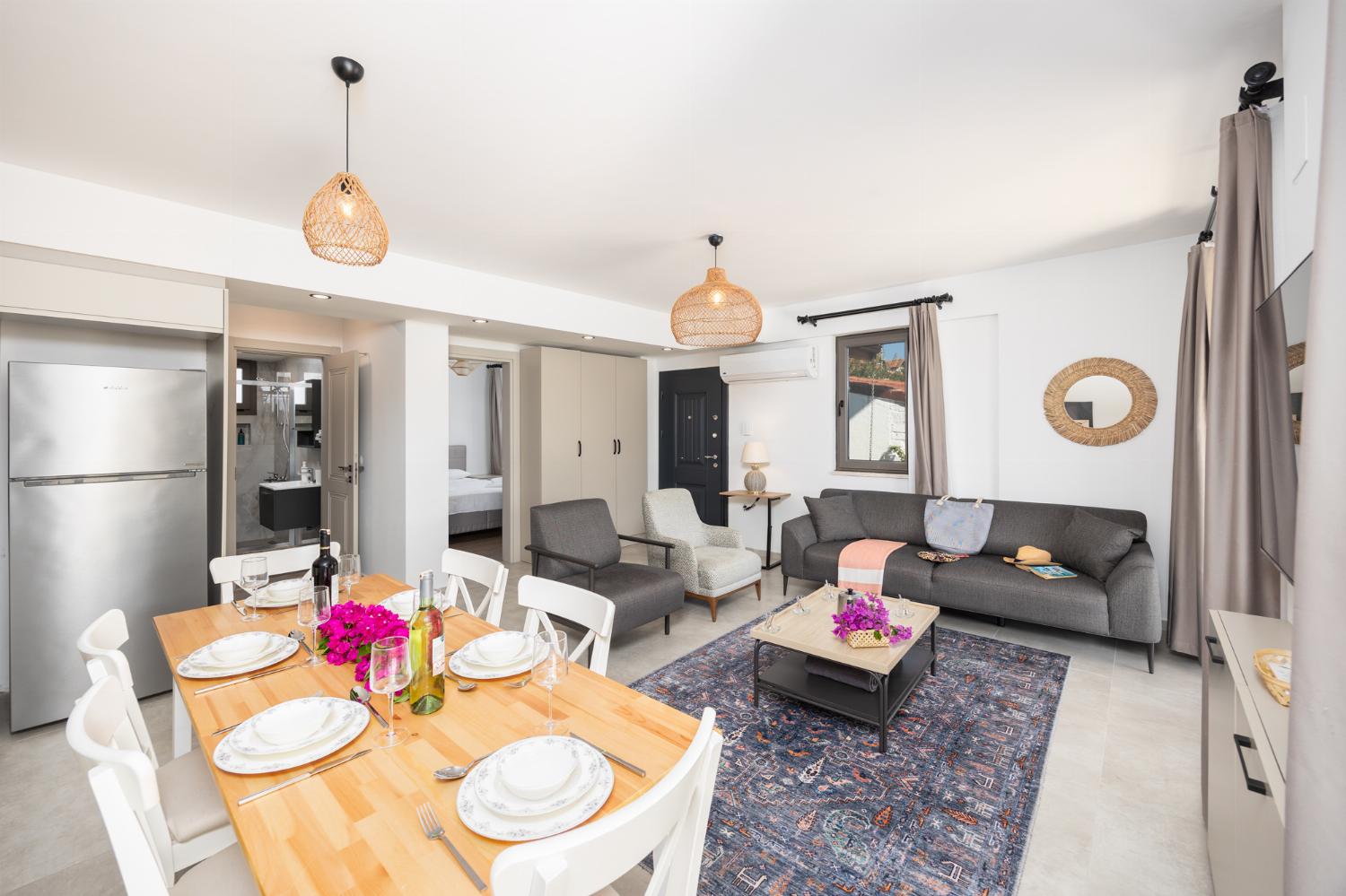 Open-plan living room with sofa, dining area, kitchen, A/C, WiFi internet, and satellite TV