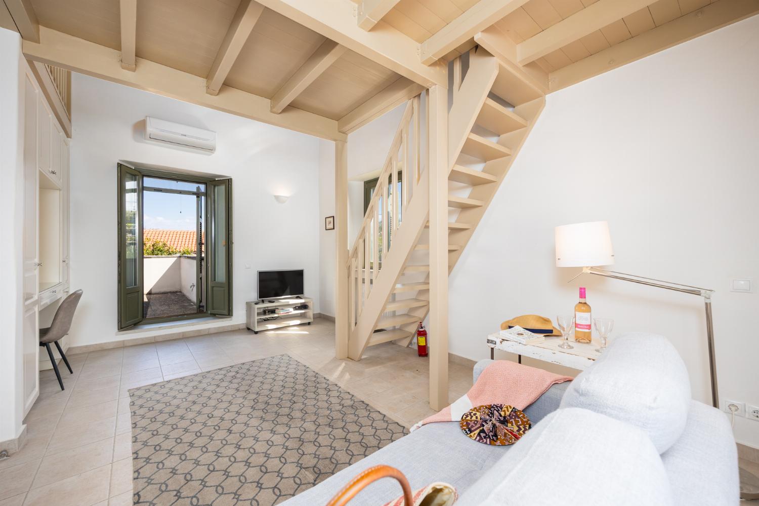 Main building: Bedroom with mezzanine, twin bed, sofa, ensuite bathroom, and A/C