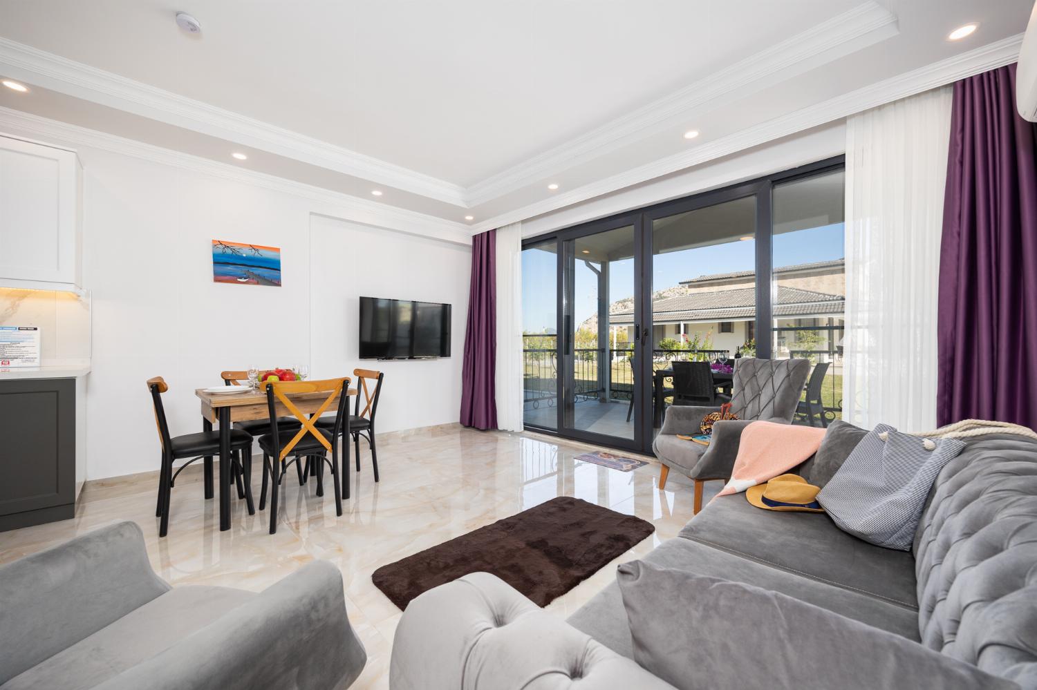 Annex: open-plan living room with sofa, dining area, kitchen, A/C, WiFi internet, and satellite TV