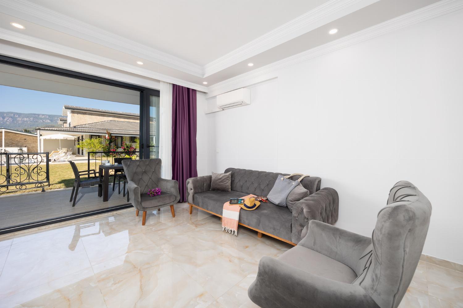 Annex: open-plan living room with sofa, dining area, kitchen, A/C, WiFi internet, and satellite TV