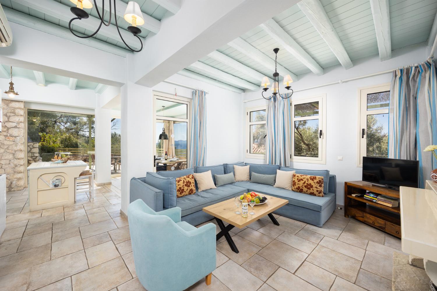 Open-plan living room with sofa, dining area, kitchen, ornamental fireplace, A/C, WiFi internet, and satellite TV