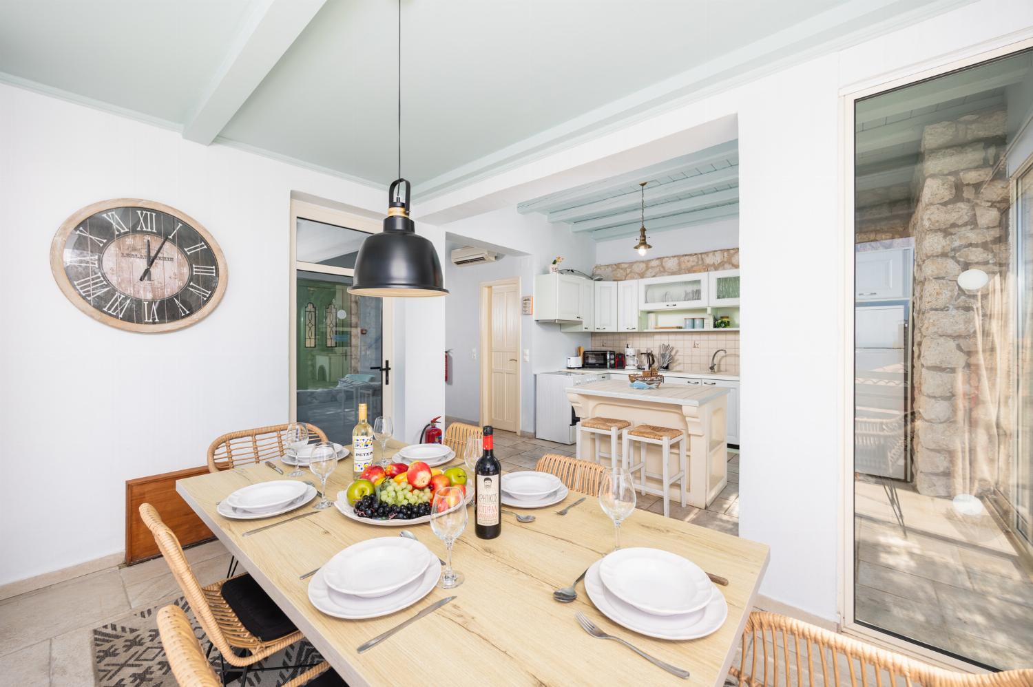 Open-plan living room with sofa, dining area, kitchen, ornamental fireplace, A/C, WiFi internet, and satellite TV