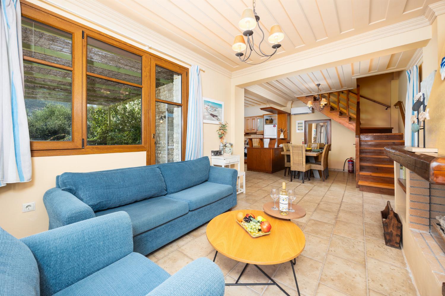 Open-plan living room with sofa, dining area, kitchen, A/C, WiFi internet, and satellite TV
