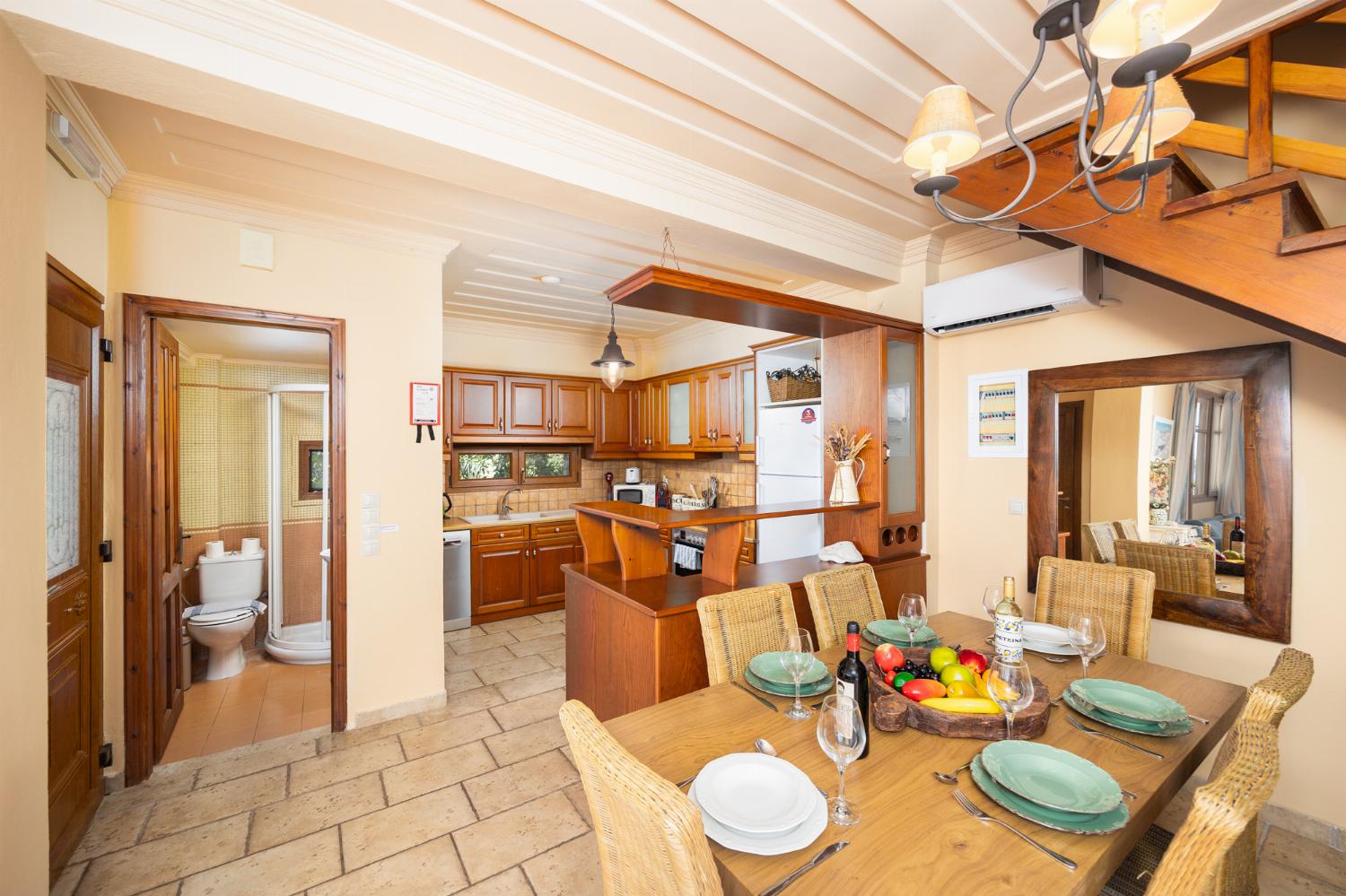 Open-plan living room with sofa, dining area, kitchen, A/C, WiFi internet, and satellite TV