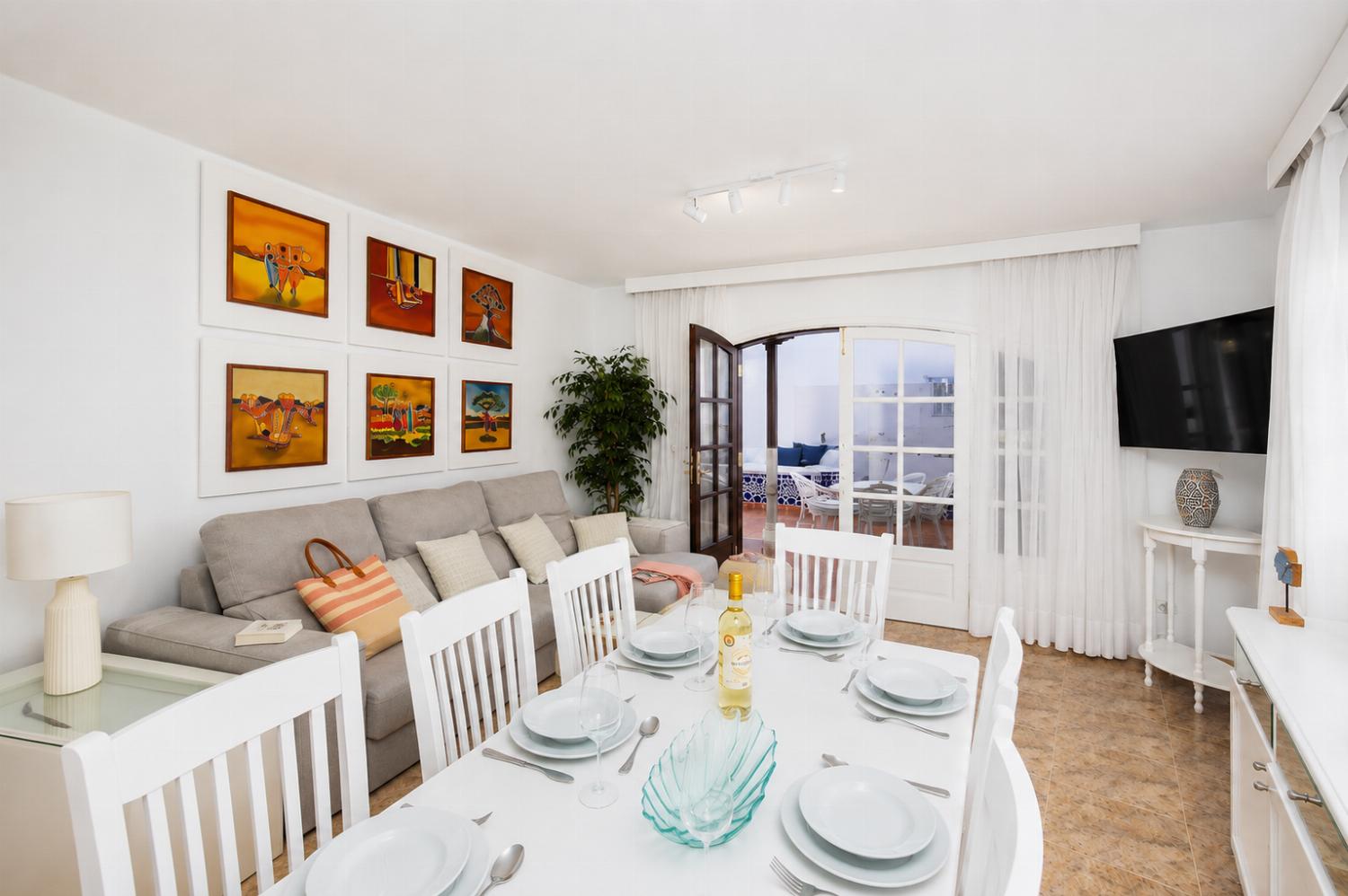 Living room with sofas, dining area, A/C, WiFi internet, and satellite TV