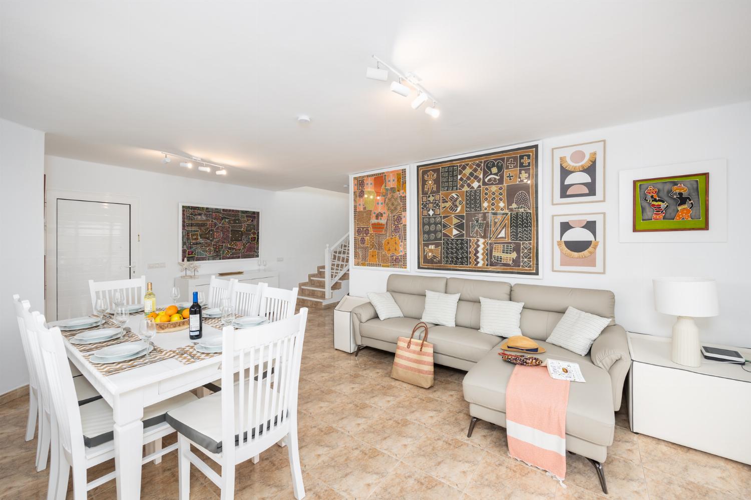 Living room with sofa, dining area, A/C, WiFi internet, and satellite TV