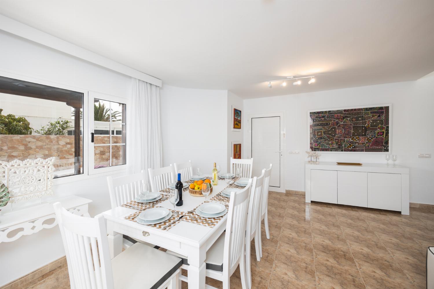 Living room with sofa, dining area, A/C, WiFi internet, and satellite TV