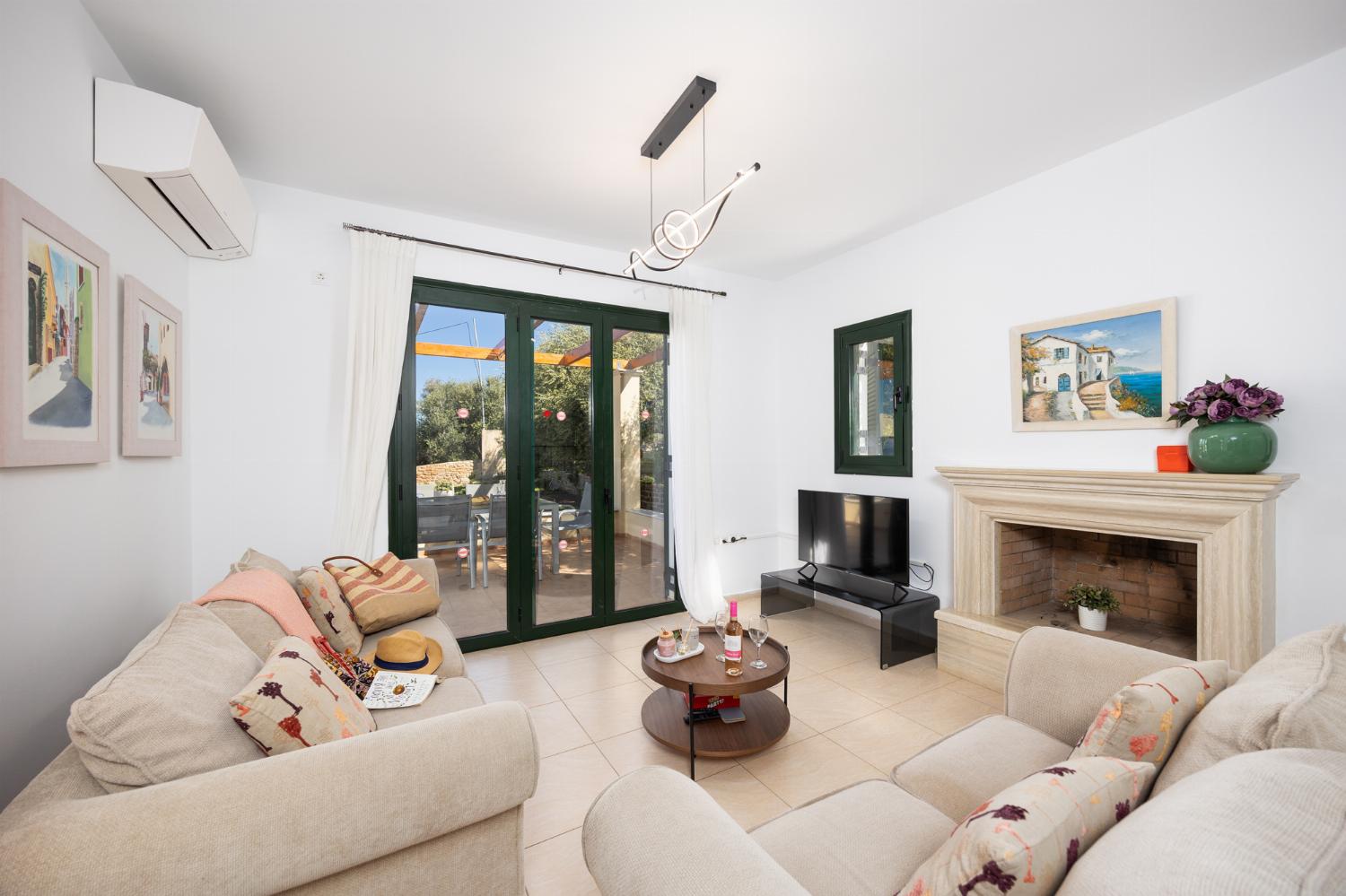 Open-plan living room with sofas, dining area, kitchen, ornamental fireplace, A/C, WiFi internet, satellite TV, and sea views
