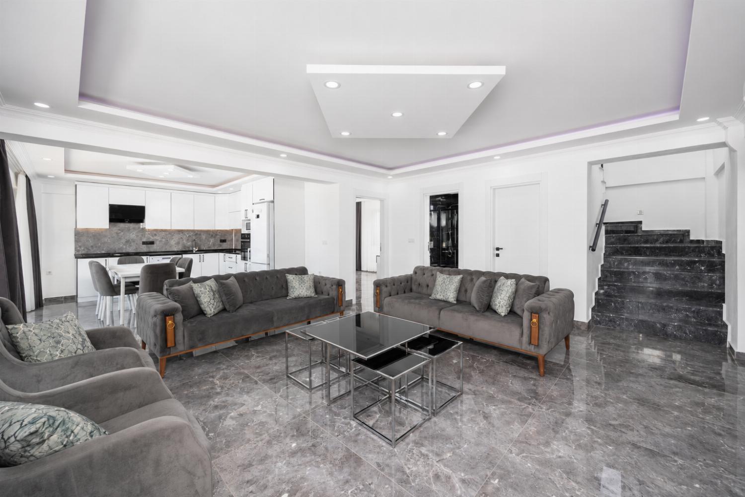 Open-plan living room with sofas, dining area, kitchen, A/C, WiFi internet, and satellite TV