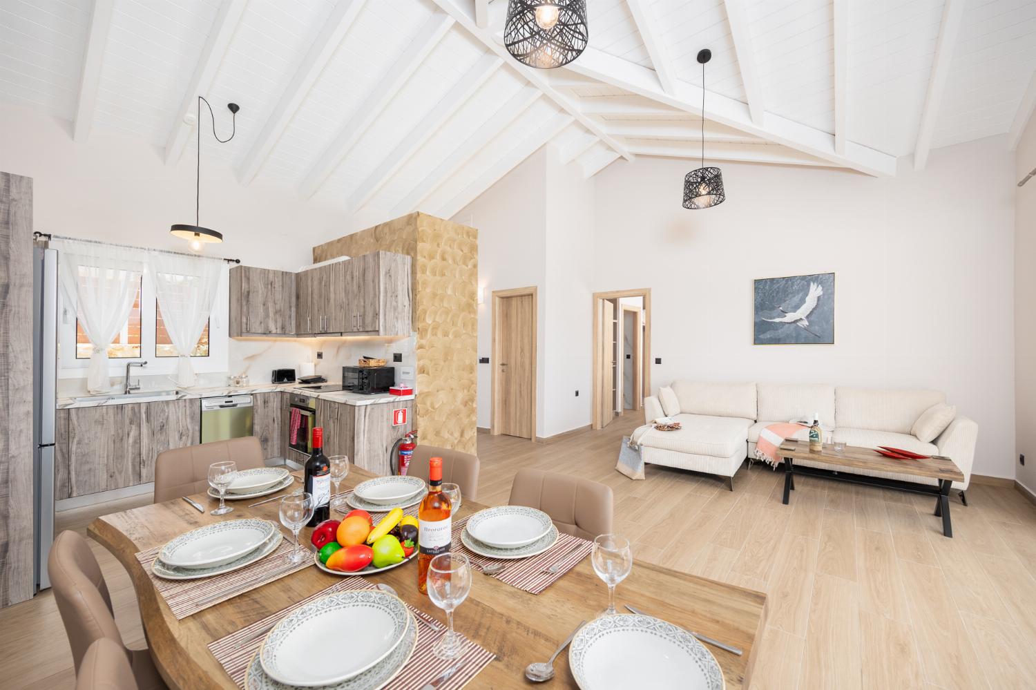 Open-plan living room with sofa, dining area, kitchen, A/C, WiFi internet, and satellite TV