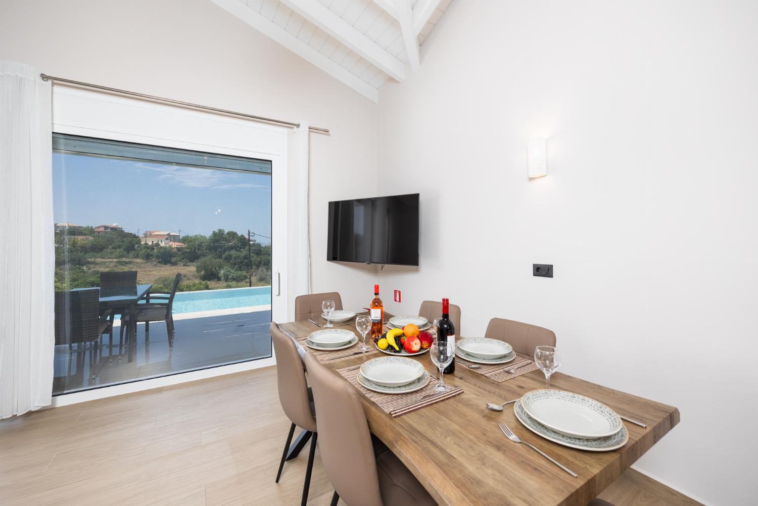 Open-plan living room with sofa, dining area, kitchen, A/C, WiFi internet, and satellite TV