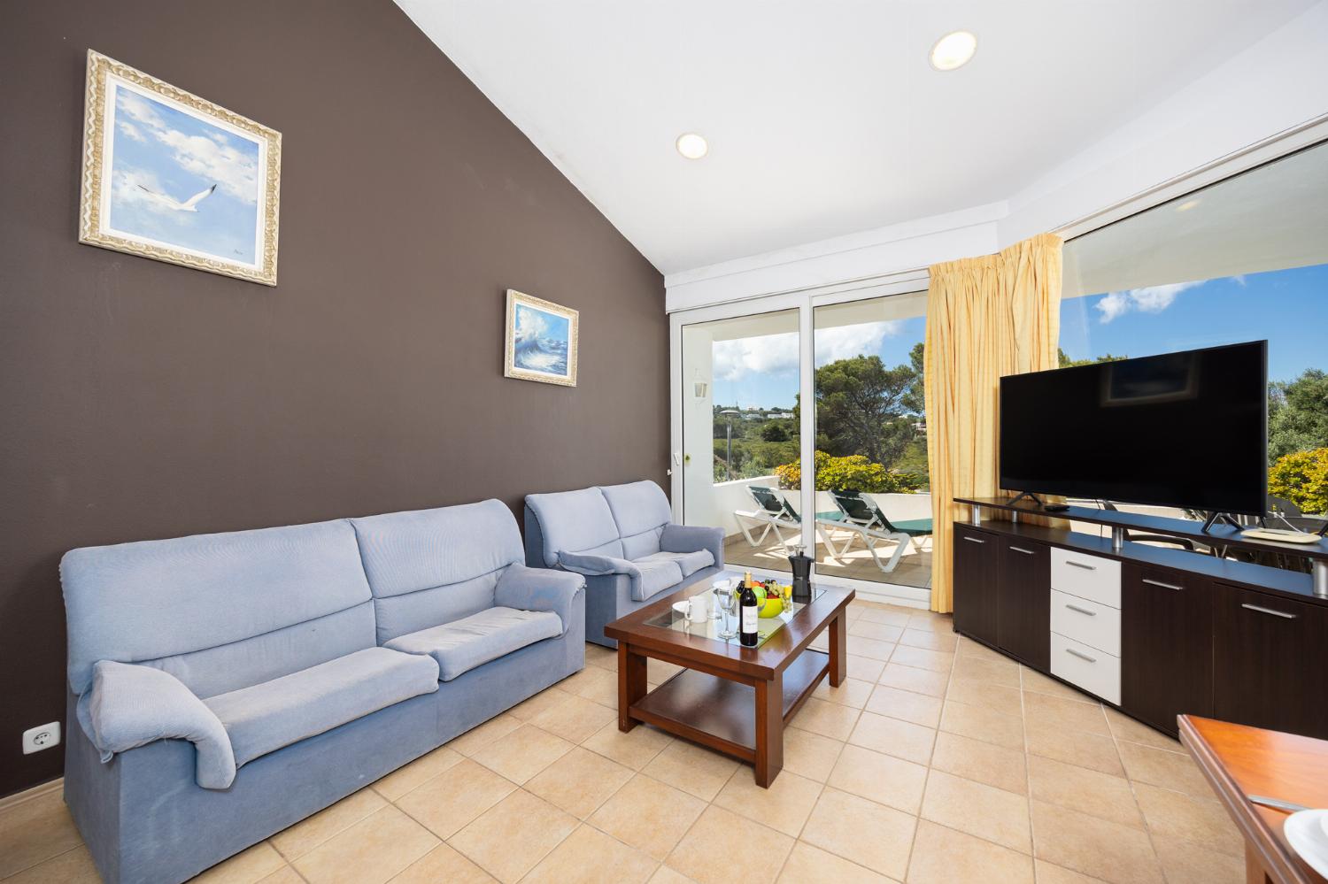Living room with sofas, dining area, ornamental fireplace, WiFi internet, and satellite TV