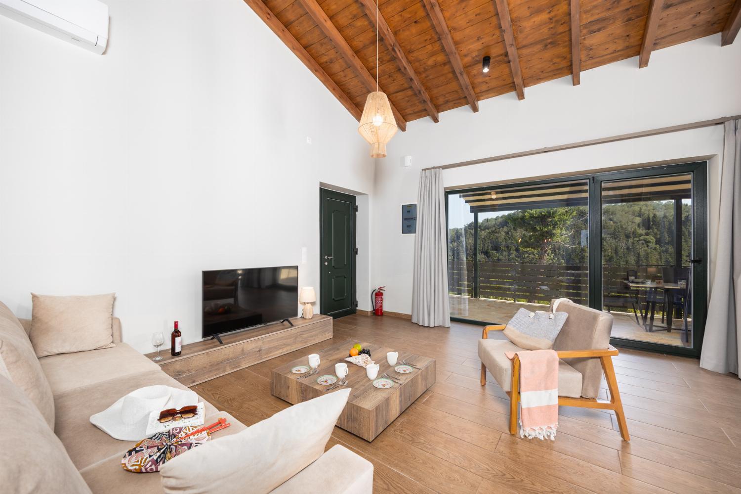 Open-plan living room with sofa, kitchen, A/C, WiFi internet, and satellite TV