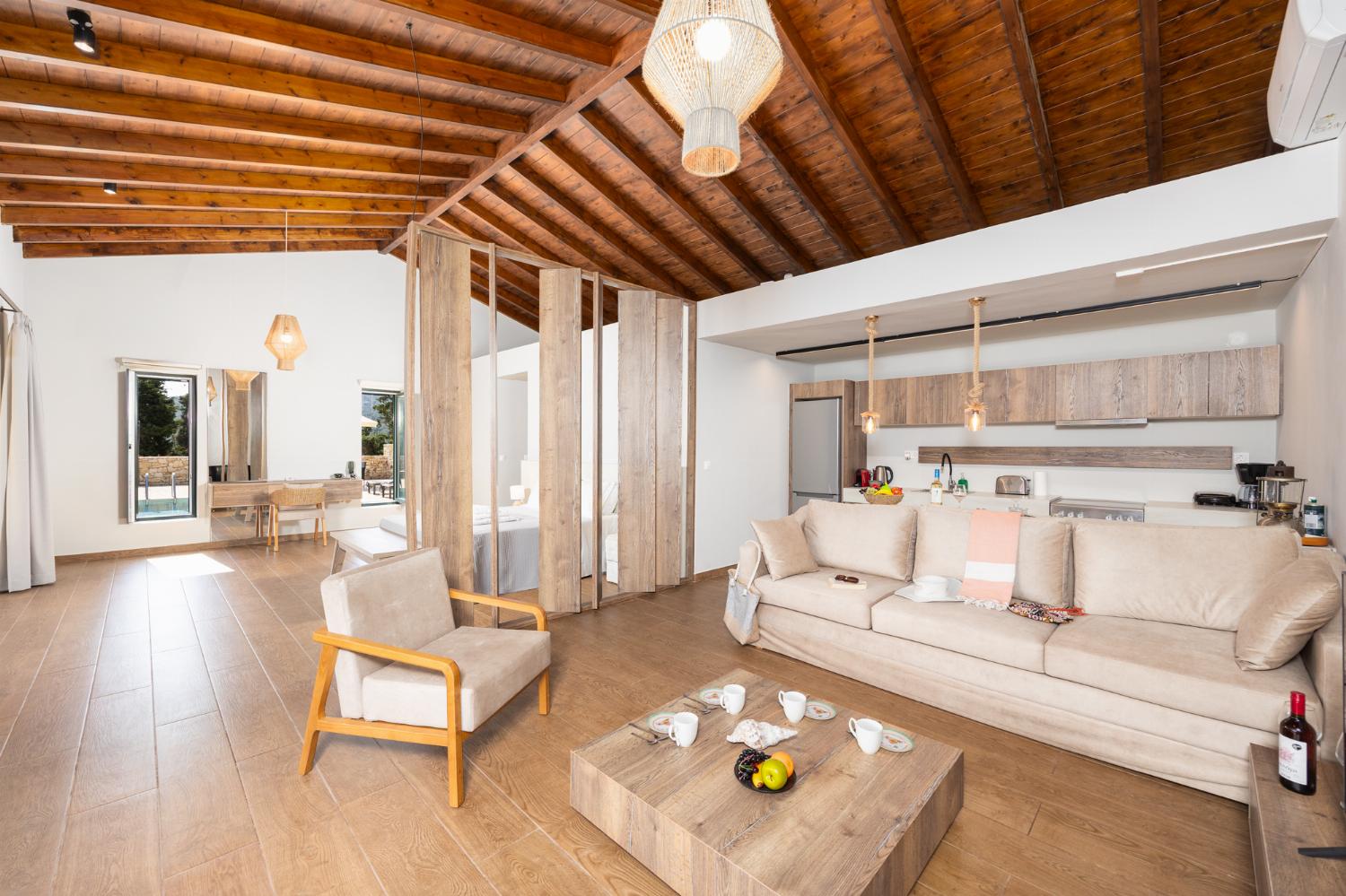 Open-plan living room with sofa, kitchen, A/C, WiFi internet, and satellite TV
