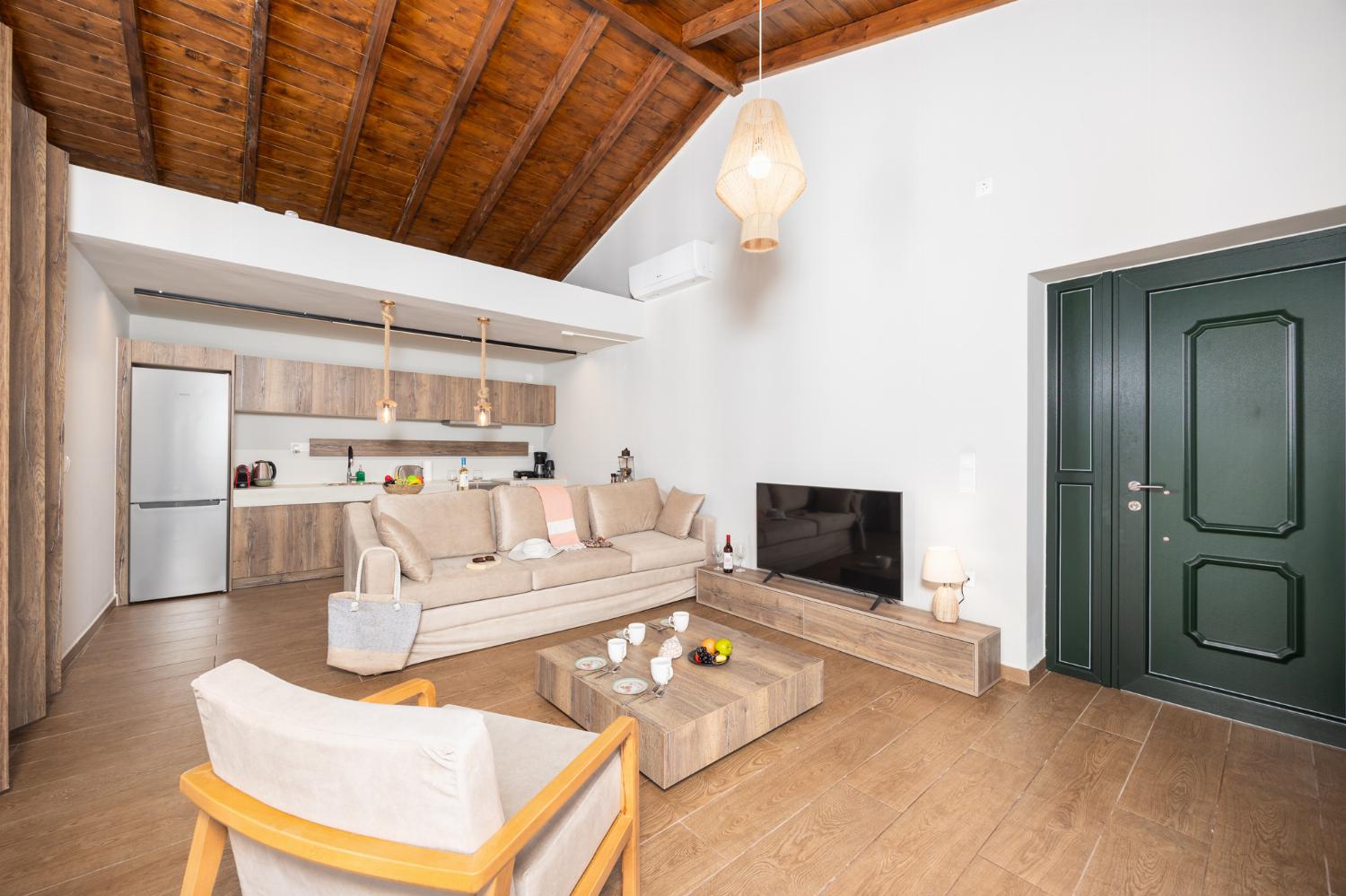 Open-plan living room with sofa, kitchen, A/C, WiFi internet, and satellite TV