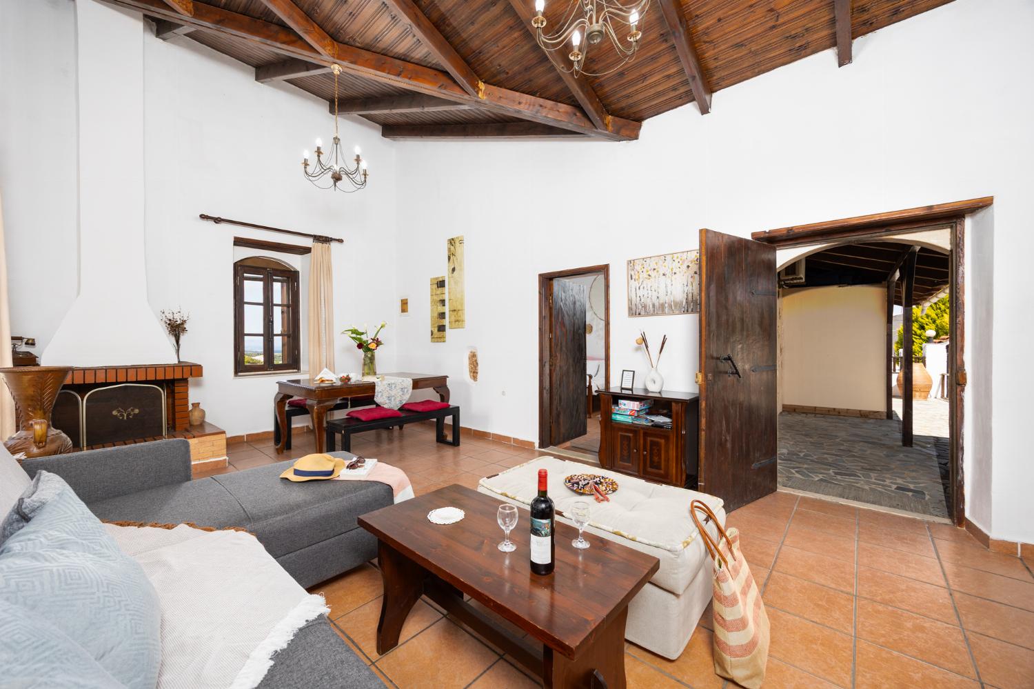 Open-plan living room with sofa, dining area, kitchen, ornamental fireplace, WiFi internet, and satellite TV