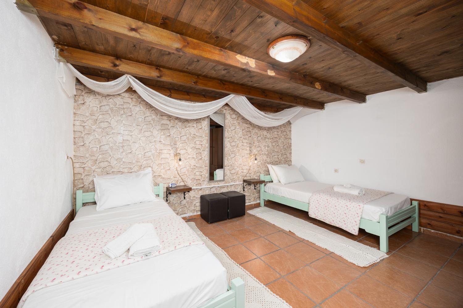 Bedroom with twin bed, double bed, en suite bathroom, and A/C
