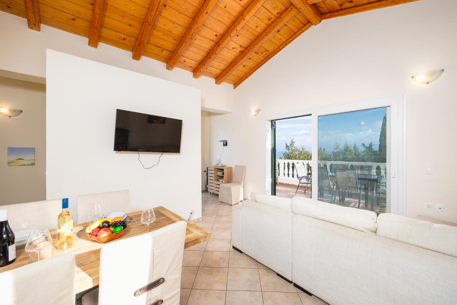 Open-plan living room with sofa, dining area, kitchen, A/C, WiFi internet, and satellite TV