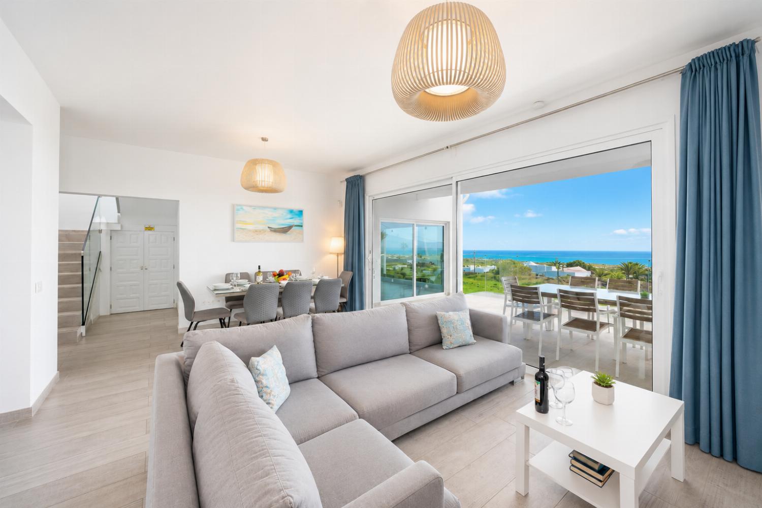 Open-plan living room with sofa, dining area, kitchen, A/C, WiFi internet, satellite TV, and sea views