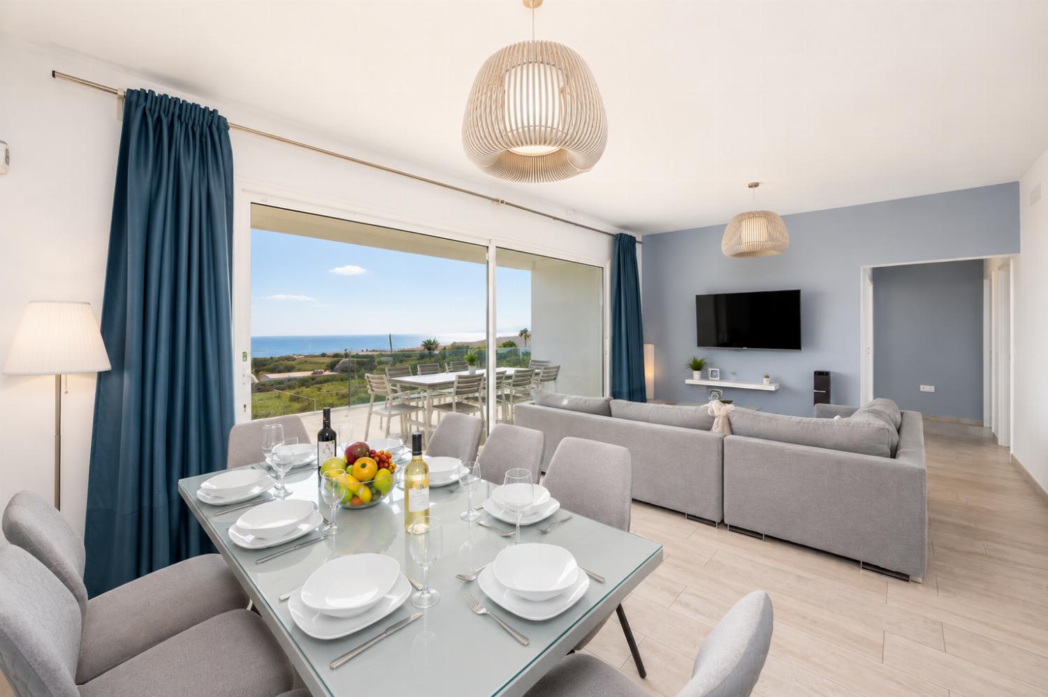 Open-plan living room with sofa, dining area, kitchen, A/C, WiFi internet, satellite TV, and sea views