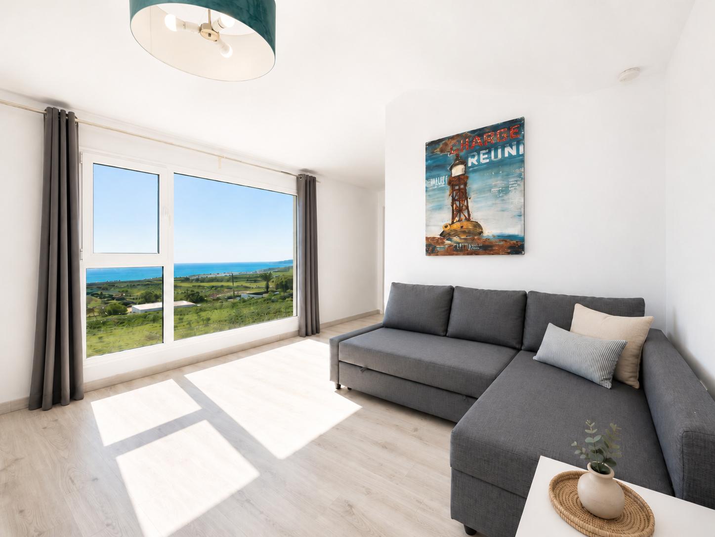 Double bedroom with en suite bathroom, A/C, living area, and sea views